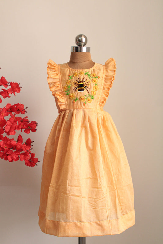 Beige dress with floral embroidery on a mannequin against a beige background